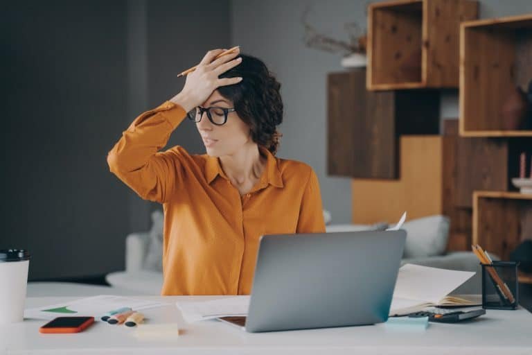 Frustrated Italian female employee stressed about mistake or problem with computer
